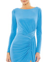 This elegant Duggal jersey, bodycon, turquoise evening dress is sophisticated in every way. With long sleeves and a floor-length skirt together with faux wrap detail at the waist and one sexy thigh high split. This gorgeous aqua gown is perfect for proms, black-tie affairs, weddings and special events close up